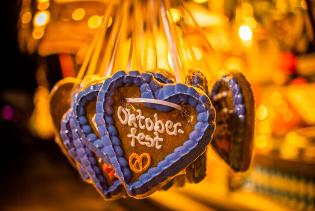 Lebkuchenherzen hängen an einem Stand mit der Aufschrift „Oktoberfest“