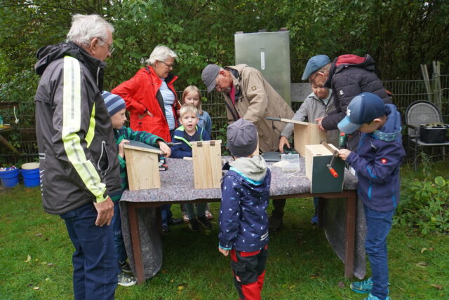 Kinder bauen mit Hilfe Futterkästen