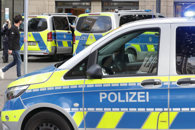 Mehrere Streifenwagen der Polizei parken vor einem Gebäude.