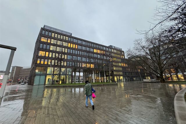 Eine Passantin läuft auf das BIG-Gebäude in Dortmund zu.