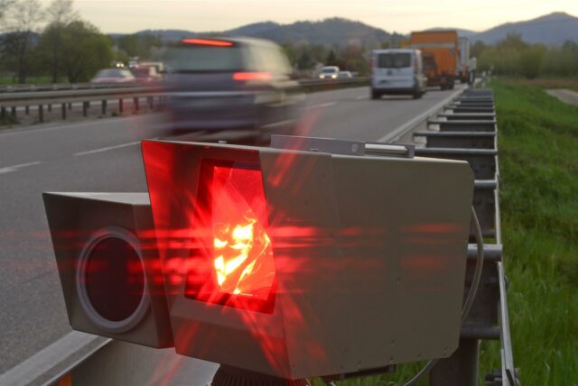 Eine Radarfalle am Rande einer Autobahn löst aus.