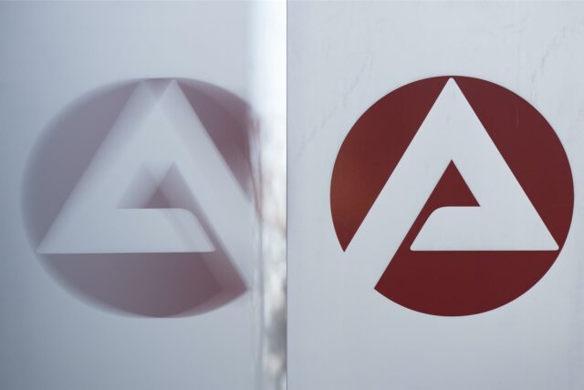 Das Logo der Bundesagentur für Arbeit spiegelt sich in einer Scheibe.
