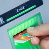 Eine EC-Karte wird in einen Automaten geschoben.