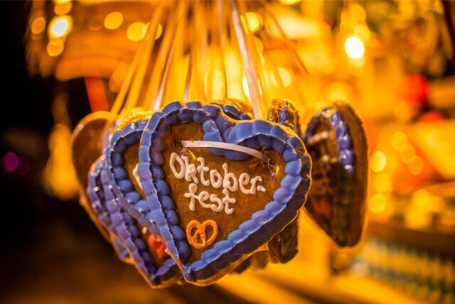 Lebkuchenherzen hängen an einem Stand mit der Aufschrift „Oktoberfest“