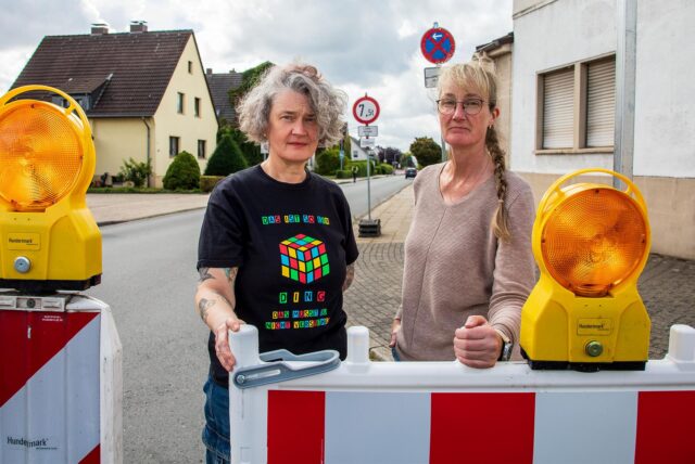 Die Hertenerinnen Heike und Uta Kirchhoff stehen an einer rot-weißen Straßenabsperrung an der Uhlandstraße in Herten-Disteln.