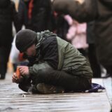 Ein Bettler auf dem Westenhellweg, davor eine Montage der sieben wichtigsten Dortmunder OB-Kandidaten
