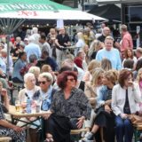 Menschen an Bänken auf dem Straßenfest in Hombruch. 