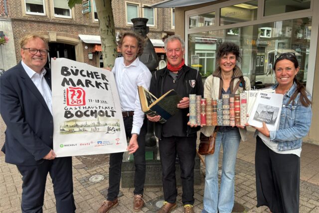 Werben für den 34. Bocholter Büchermarkt (v. re.): Jule Wanders (Stadt Bocholt), Antiquarin Monika Grevers, Antiquar und Organisator Rainer Heeke sowie Sponsor Michael Deutz und Bernd Kleine-Rüschkamp von der Volksbank, die die Veranstaltung ebenfalls als Sponsorin unterstützt. Die Gruppe steht vor dem Tutemann am Gasthausplatz, wo der Büchermarkt am 7. September stattfinden wird.