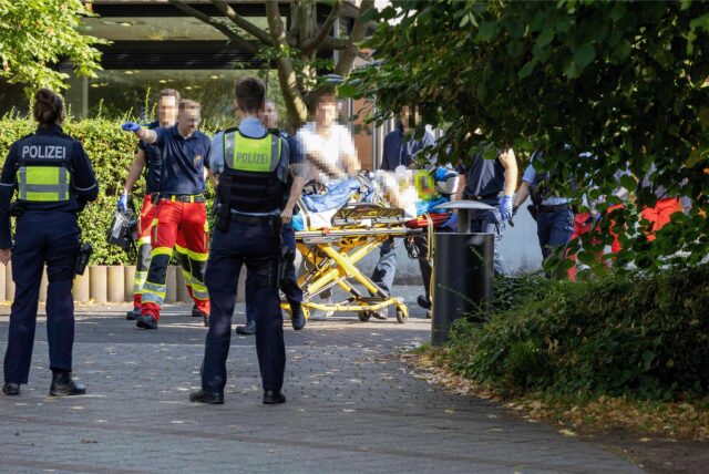 Die verletzte Lehrerin wird von Rettungskräften auf einer Liege aus der Schule gebracht.
