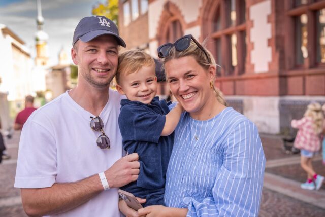 Eine Familie lacht beim Cityring-Konzert auf dem Friedensplatz in Dortmund in die Kamera.