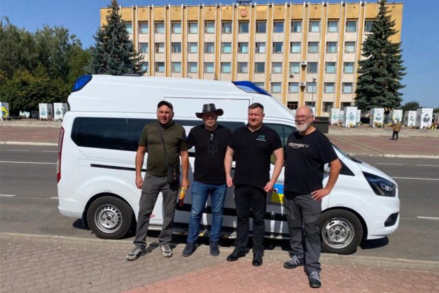 Mario Nienkemper, Peter Hilbig und Empfänger Oleg zeigen den überführten Rettungswagen auch Wiktor Saposchnikow, dem Bürgermeister von Nowowolyns