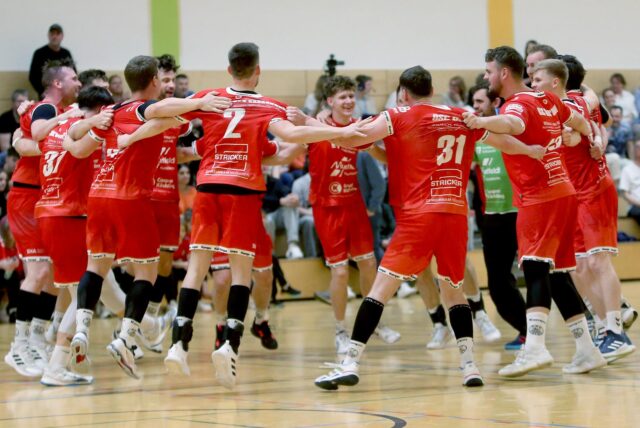Spieler springen im Kreis und jubeln.