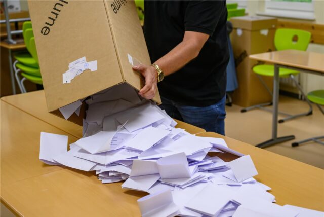 In einem Wahllokal wird eine Wahlurne mit den Stimmzetteln ausgeschüttet.