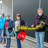 Menschen halten Tücher und stehen nebeneinander.