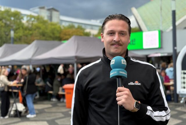 Tim Hübbertz steht auf dem Feierabendmarkt in Dortmund und lächelt in die Kamera.