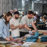 Drei Personen sortieren Wahlbriefe zur Kommunalwahl 2025 in Dortmund.