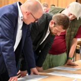 Julian Fragemann (links) und Swen Coralic (Mitte) begutachten die im Dorstener Ratssaal ausgelegten Wahlergebnisse.