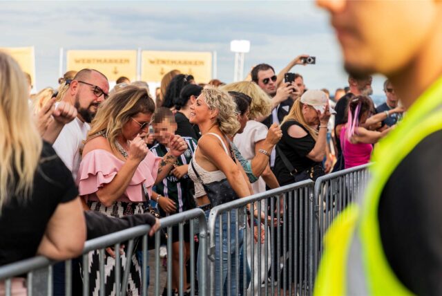 Beim SunsetPicknick am 6. September 2025 auf der Halde Hoheward in Herten tanzen Frauen und Männer hinter einer Absperrung.