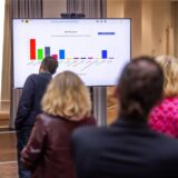 Collage: links Bezirksbürgermeister Heiko Brankamp (SPD) aus Lütgendortmund, Menschen schauen im Rathaus Dortmund auf einen Bildschirm, der  Wahlergebnisse der Kommunalwahl 2025 anzeigt