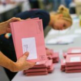 Jemand schaut Briefwahlunterlagen durch.