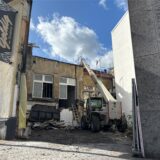In einem Innenhof zwischen zwei Gebäuden in der Innenstadt von Recklinghausen steht ein Kranfahrzeug. Das Gebäude Holzmarkt 8 am Kirchplatz ist einsturzgefährdet und wird abgerissen.