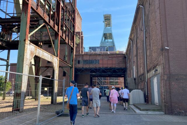 Mehrere Personen gehen bei einer Führung über das Gelände der Zeche Ewald in Herten.