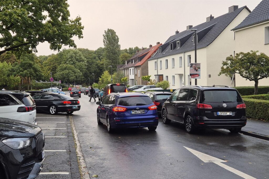 Die Lunastraße am Morgen eines Schultags: Links und rechts parken Autos, in der Mitte ist eine Spur, die als Einbahnstraße befahren wird.