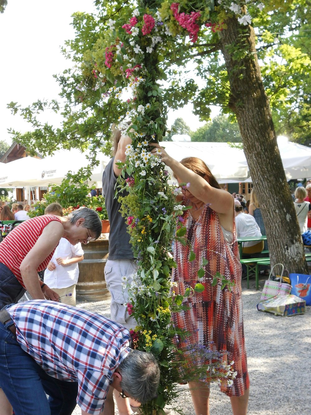 Die Mitglieder der Deutsch-Schwedischen-Vereinigung dekorieren die Midsommar-Stange, um die beim Midsommar-Fest getanz wird.