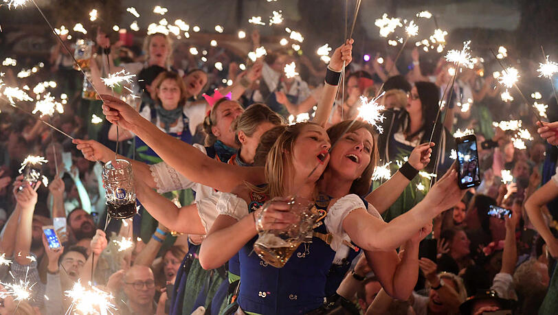 Bedienungen im Hofbräu-Festzelt tanzen und feiern beim Wiesn-Kehraus auf den Tischen.