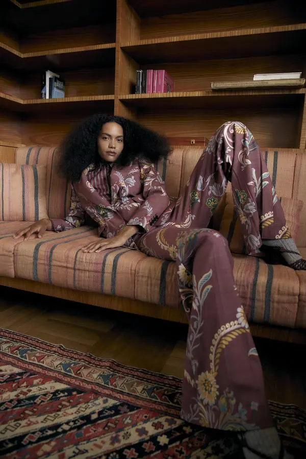 Etro. Barbara trägt eine ausgestellte Hose mit plissiertem Saum zum schmalen Hemd, darüber einen einreihigen Blazer aus Wollstoff mit Blumenmuster.