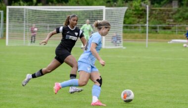 Spielerin in Hellblau dribbelt den Ball, verfolgt von Spielerin in Schwarz. Im Hintergrund steht ein Fußballtor. Foto: Sandra Ritschel