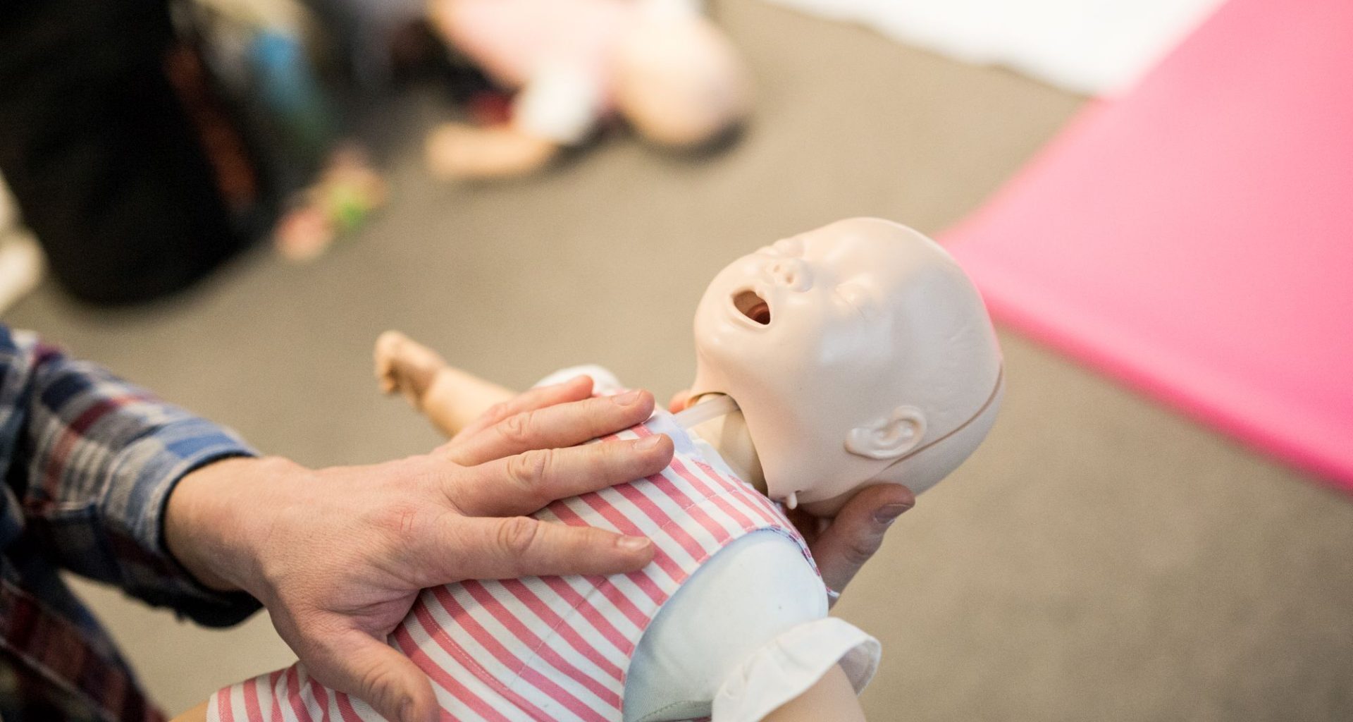 Erste-Hilfe-Kurs in Magdeburg für Eltern mit Babys und Kleinkindern am 21. Januar 2016 in Magdeburg. In einem dreistündigen Seminar erläutert und demonstriert Kursleiter, Elias Becker wie in Notfällen zu handeln ist. Herzmassage / Detail einer Babypuppe.