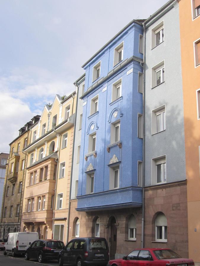 Fantasievoll und bunt zeigen sich die Häuser Ritter-von-Schuh-Platz noch heute. Die beiden linken Häuser (Nr. 29 und 31) stammen von Hermann Hubert, die Nr. 33 (Bildmitte) von Karl Illauer.