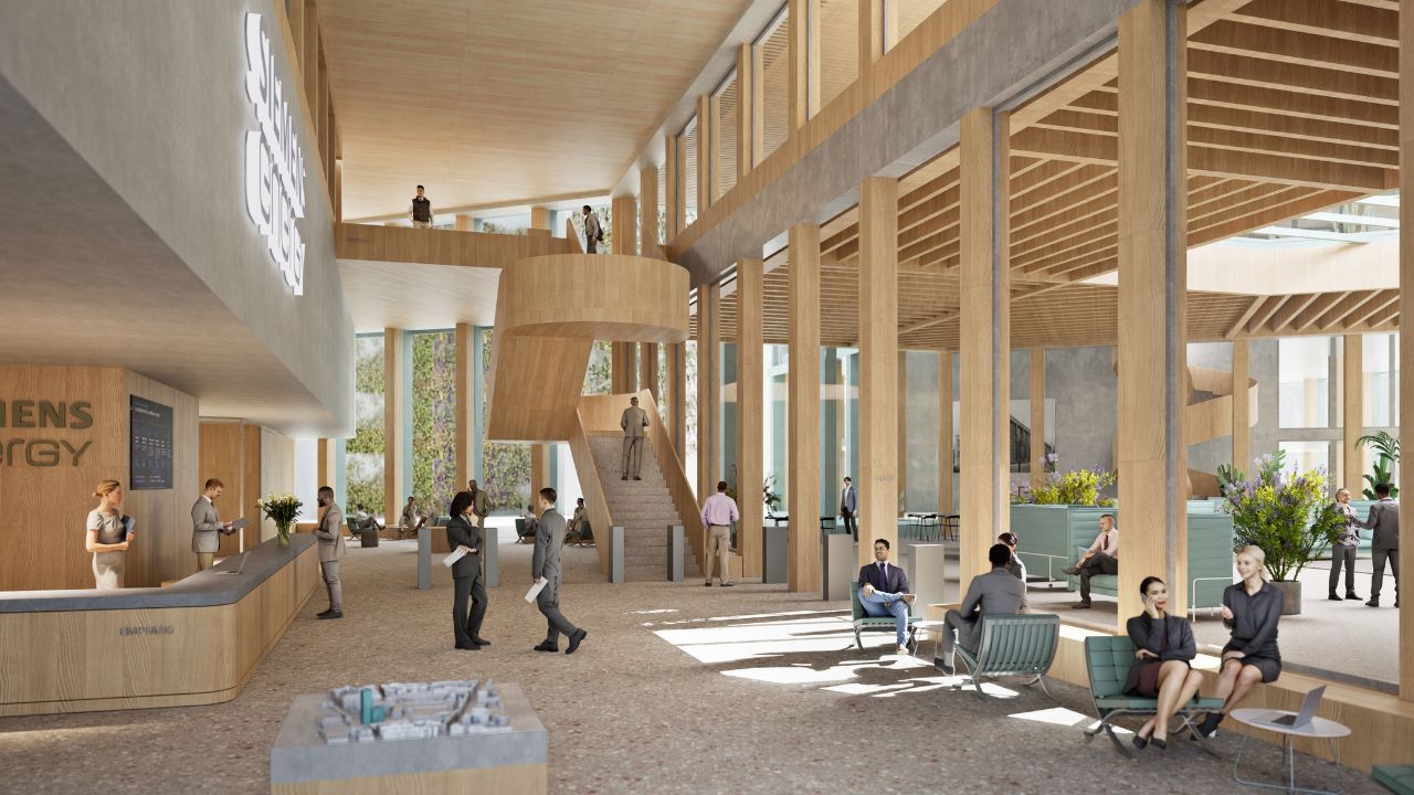 Auf dem Bild ist der Empfangsbereich mit einer Treppe und Aufenthaltszonen zu sehen.