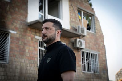 Der ukrainische Präsident Wolodymyr Selenskyj betrachtet die Zerstörung eines Wohnhauses, in dem russische Raketen 22 Bewohner getötet haben.