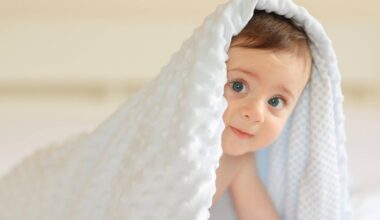 Abnehmspritzen können Kinderwunsch erfüllen: Ein Baby krabbelt unter einer weißen Decke hervor