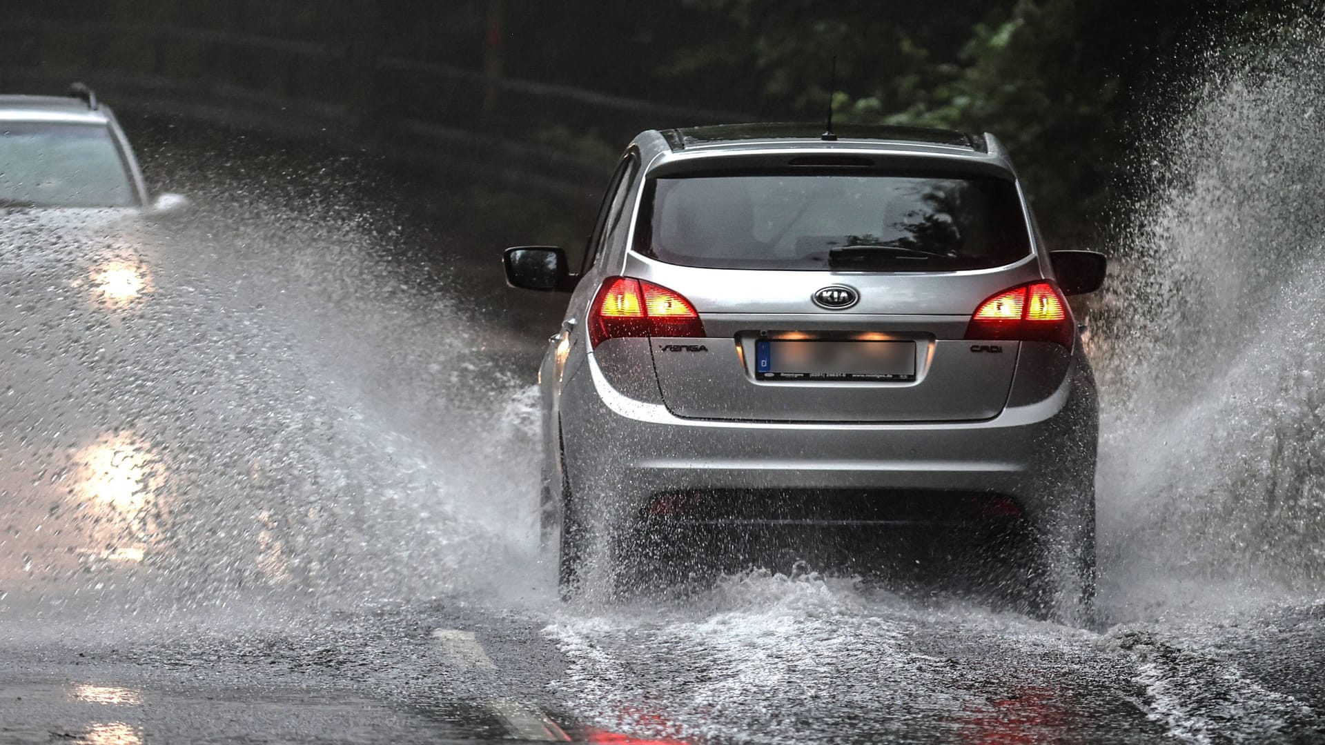 Autos fahren über eine überflutete Straße (Symbolbild): In Köln und Nordrhein-Westfalen drohen ab der Nacht zu Dienstag Starkregen, Hagel und Sturmböen.