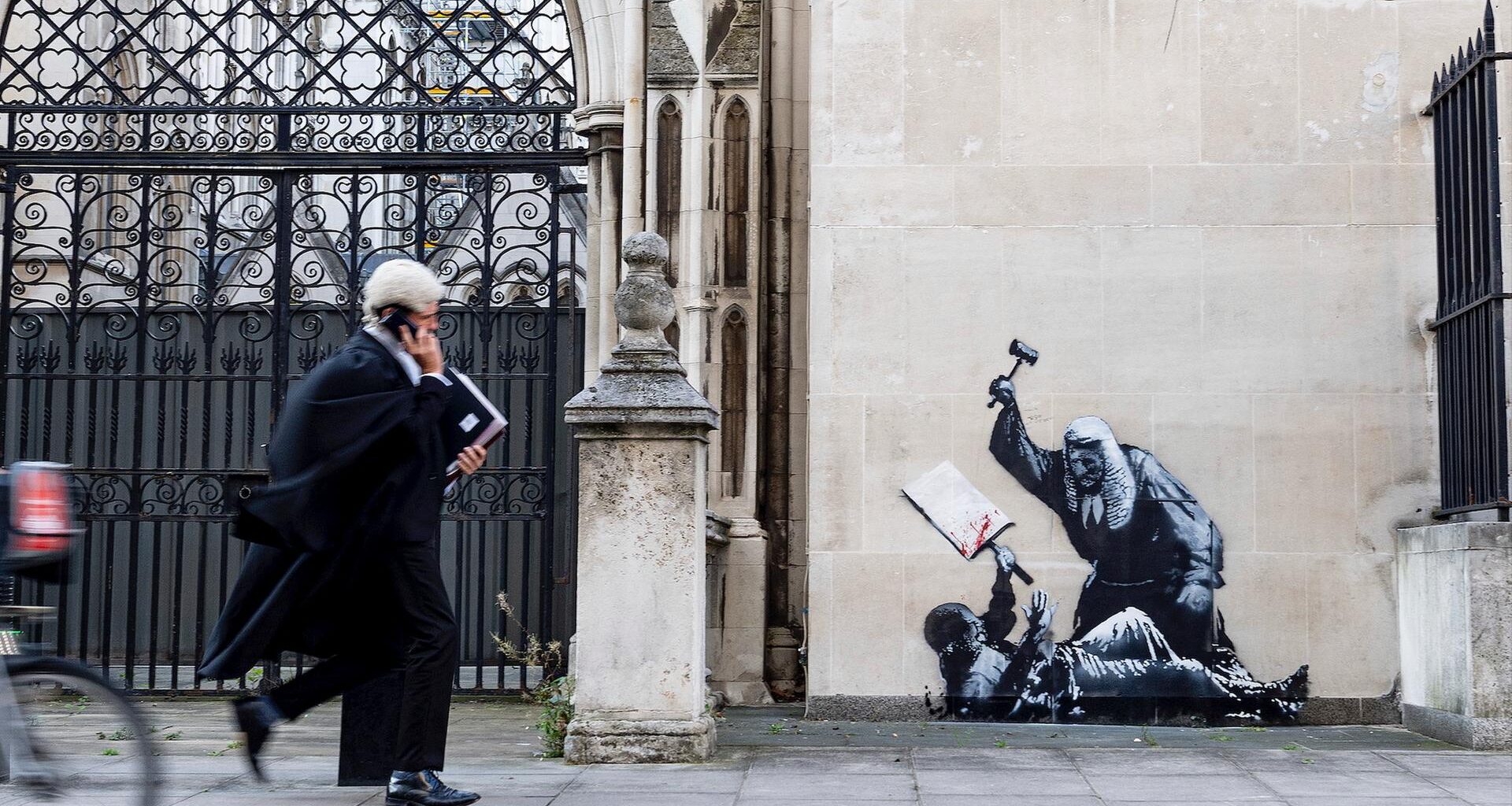 Das Foto zeigt ein Kunstwerk von Banksy. Zu sehen ist ein Richter, der einen Demonstranten im Royal Courts of Justice in London mit einem Hammer schlägt.