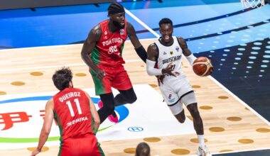 Basketballer Dennis Schröder dribbelt mit dem Ball und wird von einem Gegenspieler verfolgt.
