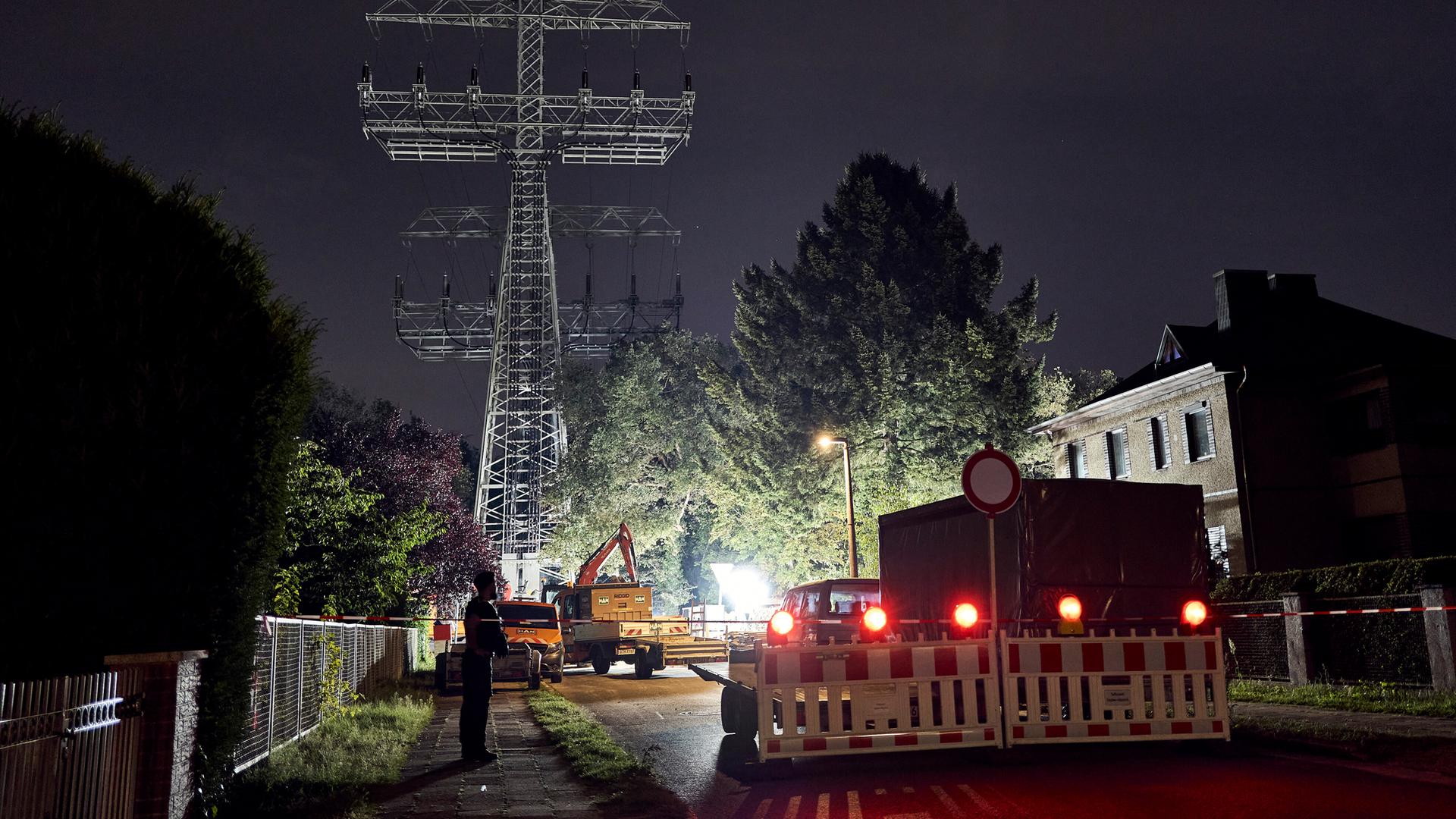 Bagger sind nachts vor einem Strommast im Einsatz. Bagger sind nachts vor einem Strommast im Einsatz.