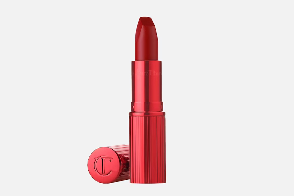 Der Charlotte Tilbury Matte Revolution Lippenstift mit geöffneter Kappe und herausgedrehtem Lippenstift auf hellem Hintergrund
