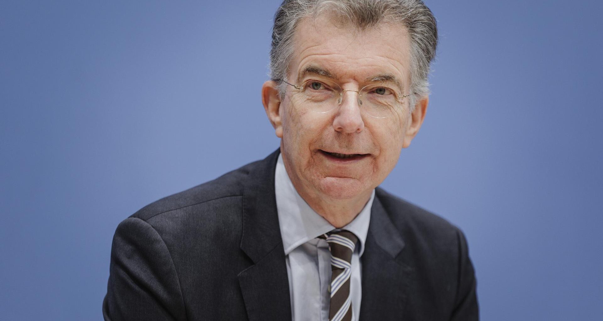 Christoph Heusgen, Politikberater; er trägt ein schwarzes Jackett, Hemd und Krawatte und sitzt vor einer bläulichen Wand.