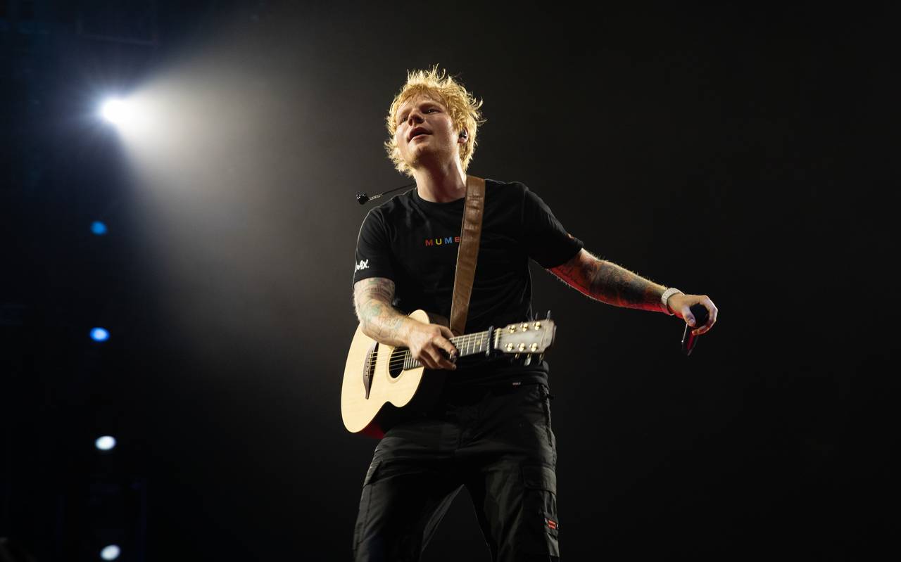 Ed Sheeran performet auf einer Bühne. Dabei wird er von einem Scheinwerfer angeleuchtet.