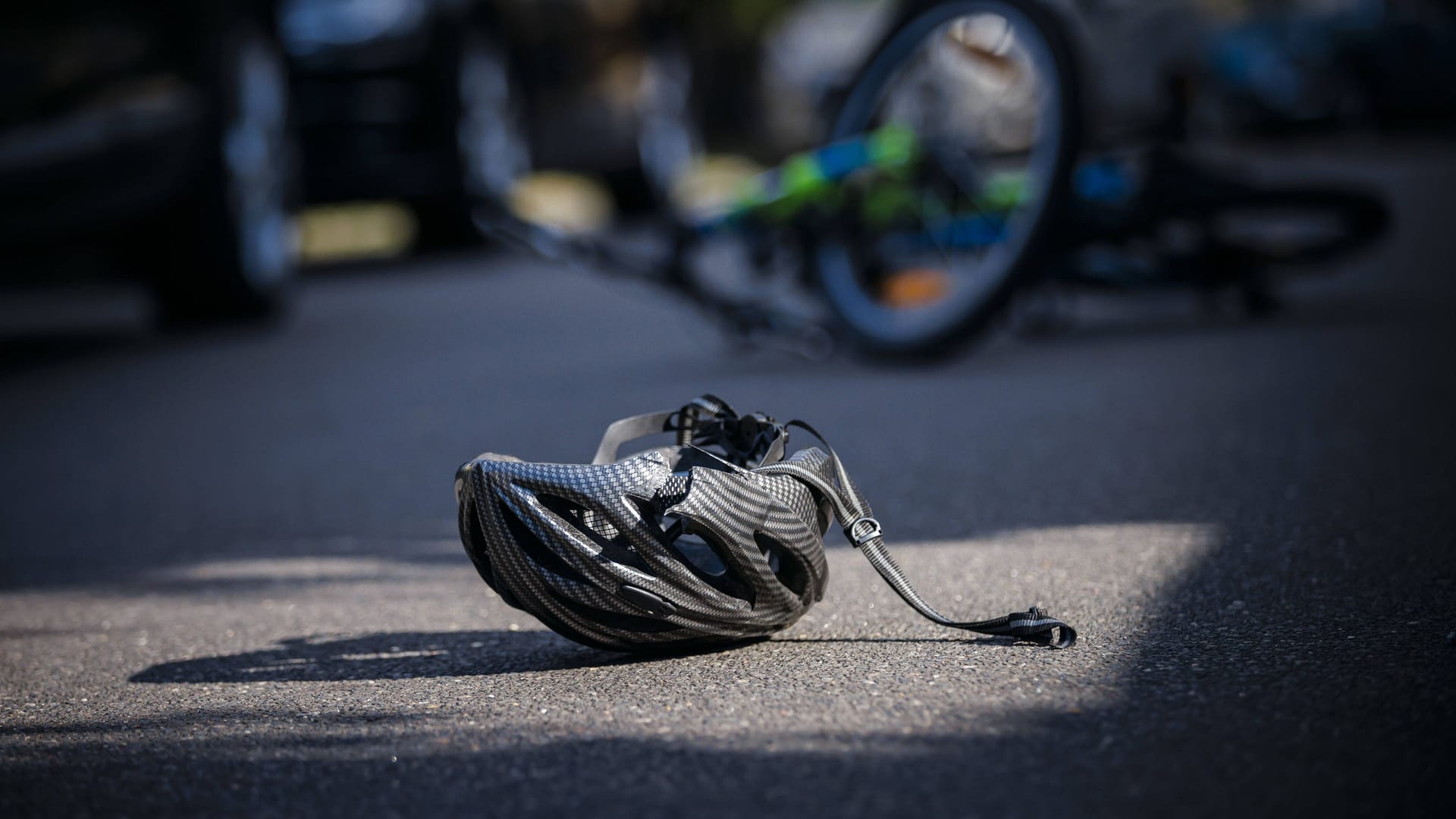 Ein Helm liegt nach einem Unfall auf der Straße (Symbolbild): In Dresden sind zwei Radfahrer verletzt worden.