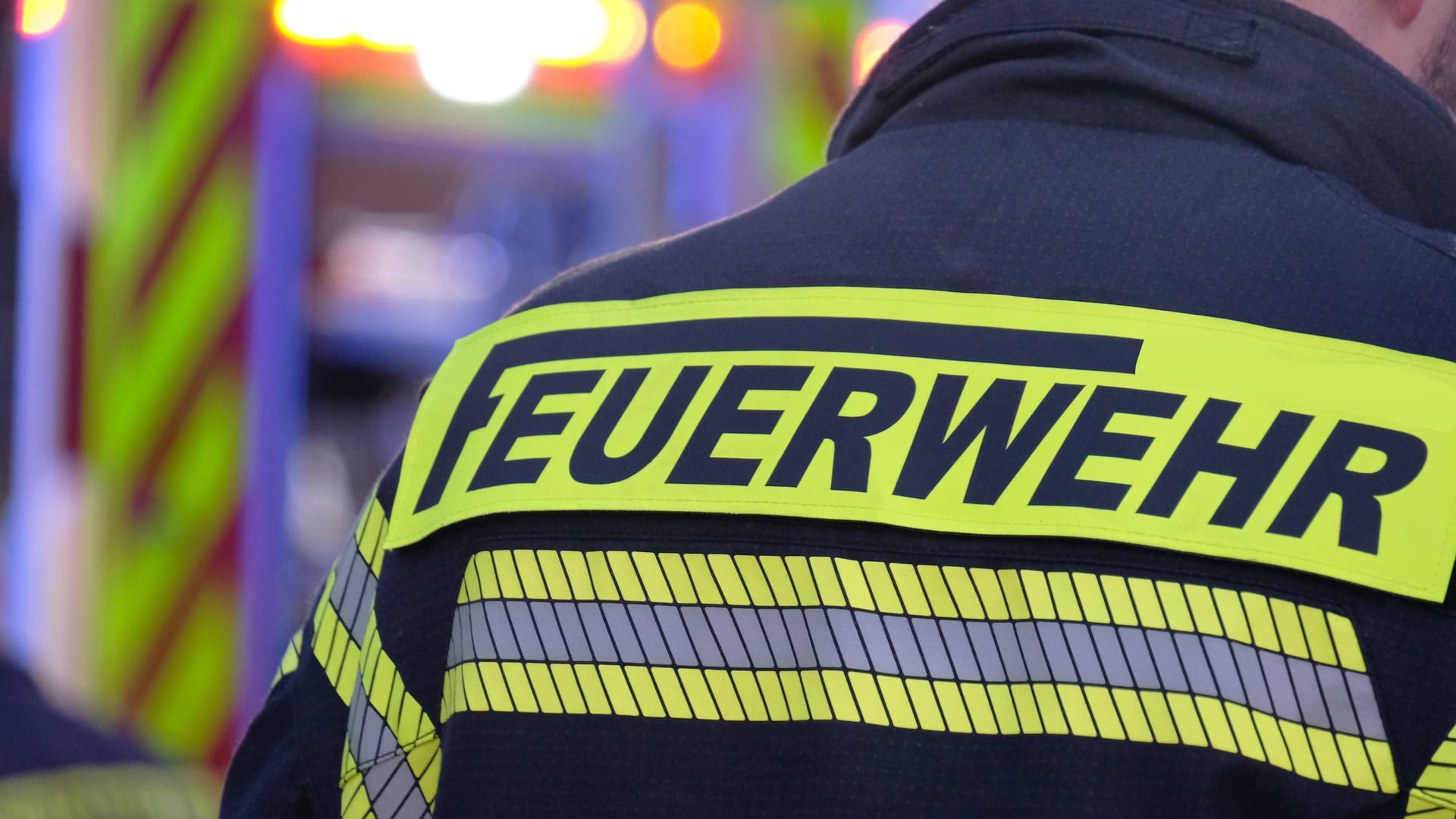 Ein Mitarbeiter der Feuerwehr steht vor einem Einsatzwagen (Symbolbild): In einer Moschee in Hannover brannte es.