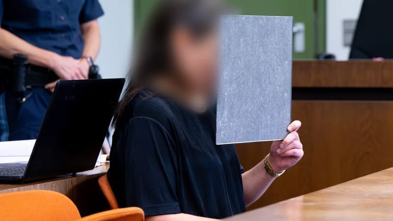 Eine angeklagte Person sitzt vor dem Prozess im Gerichtssaal: Die Bankangestellte soll Geld aus dem Tresor ihres Arbeitgebers gestohlen haben.