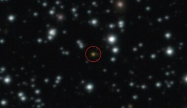 Ein astronomisches Bild zeigt einen Sternenhimmel mit zahlreichen leuchtenden Punkten vor einem dunklen Hintergrund. Ein Objekt in der Mitte ist rot eingekreist, um es hervorzuheben.