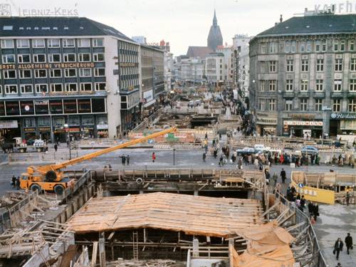Hannover-Mitte, Ernst-August-Platz , Blick Richtung Bahnhofstraße in Richtung Kröpcke. Baugrube der U-Bahn-Baustelle und Passerelle (2002 umbenannt in Niki-de-Saint-Phalle-Promenade), Foto, o. J. (um 1974)