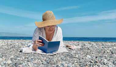 Eine Frau liest ein Buch an einem Strand