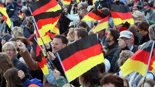 Menschen schwenken am Tag der Deutschen Einheit Nationalfahnen (Foto: IMAGO / Frank Sorge) Menschen schwenken am Tag der Deutschen Einheit Nationalfahnen (Foto: IMAGO / Frank Sorge)